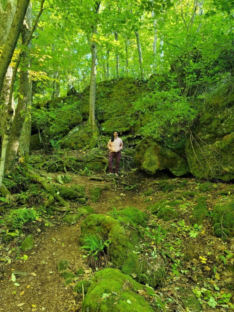 Dr. Anne in a pink jacket in a lush green forest