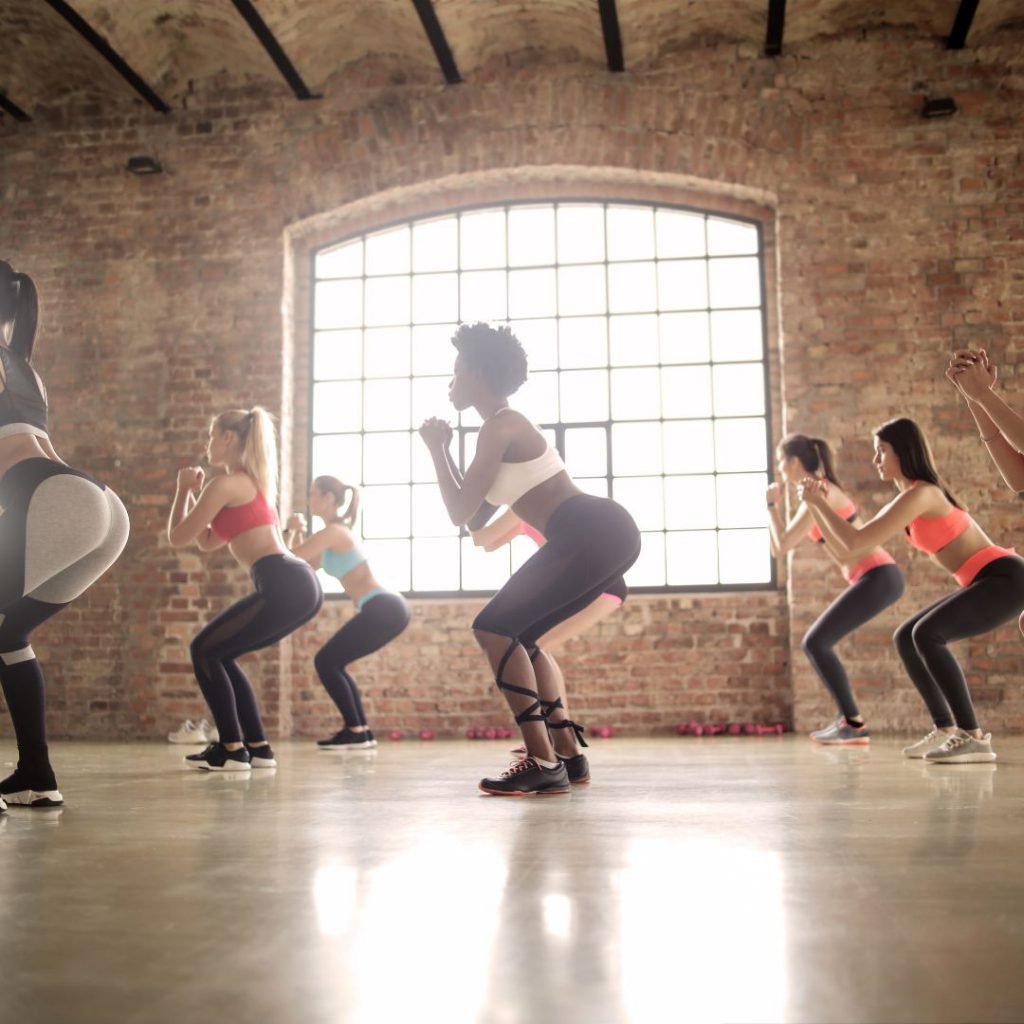 people in a gym in a squatting position