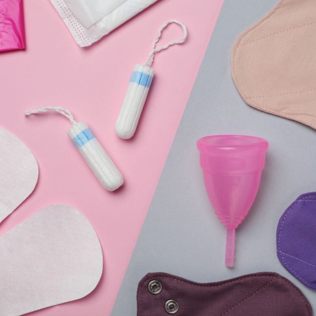 Tampons, cloth pads, disposable pads, and menstrual cup scattered across a surface